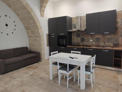 a kitchen with a white table and a couch at Dimora Gassi in Mola di Bari