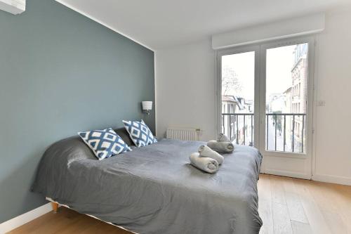 um quarto com uma cama com dois bichos de peluche em Maison d'architecte à 15 min du centre de paris ! em Asnières-sur-Seine
