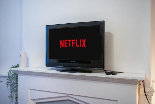 un televisor en un manto con las palabras netflix en Cozy rooms in shared accommodation near Anfield Stadium with PARKING and WIFI en Liverpool