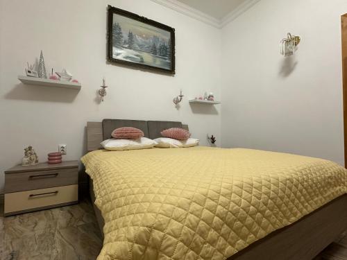 een slaapkamer met een bed en een foto aan de muur bij Cazare central Sinaia, Romania in Sinaia