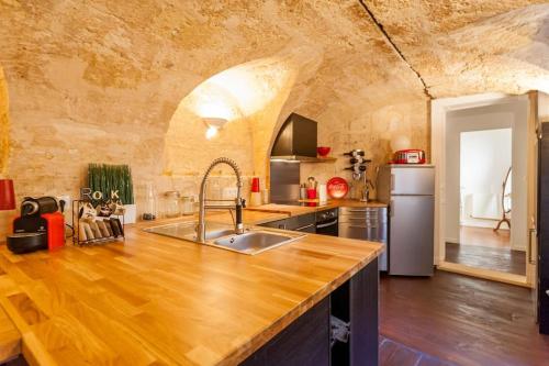 une cuisine avec un comptoir en bois dans une pièce dans l'établissement T3 de charme centre historique, à Bordeaux
