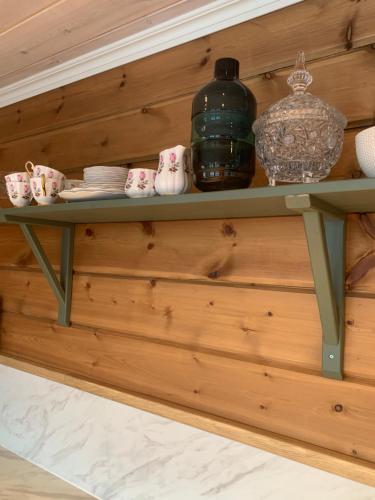 a shelf on a wooden wall with a bottle on it at Villa Flo in Stryn