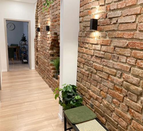 a brick wall in a hallway with a green bench at 1840 Old Town Nook in Kaunas