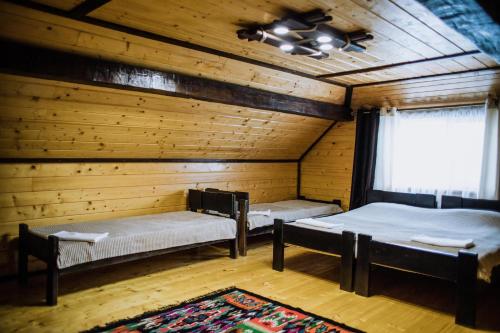 a room with two beds in a log cabin at «У полоні гір» in Verkhovyna