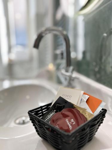 a basket sitting on a bathroom counter next to a sink at ABETI'S HOUSE in Rome