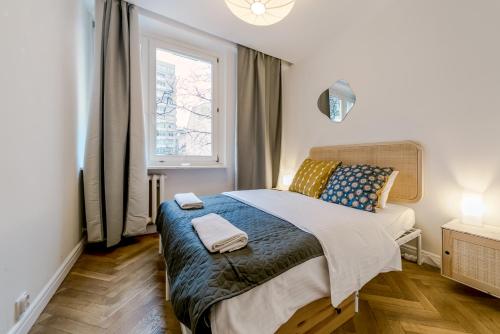 a small bedroom with a bed with a window at Warsaw Concierge Opera II in Warsaw
