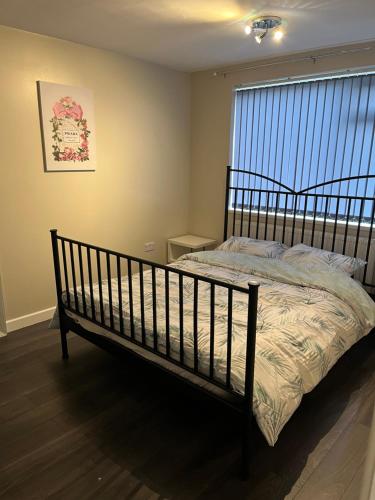 Bett in einem Zimmer mit einem Fenster und einem Bettröckchen-Brustspeck in der Unterkunft 2 bed modern ground floor apartment in Tollbar End