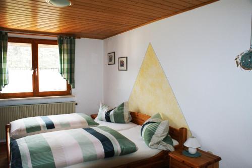 1 dormitorio con 2 camas y ventana en Pension Hessenmühle, en Haundorf