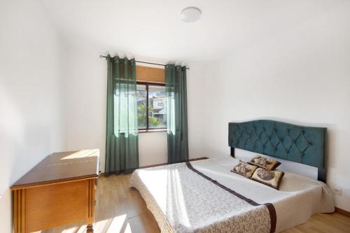 um quarto com uma cama, uma cómoda e uma janela em Gilove House em Póvoa de Varzim
