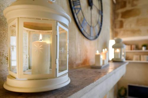 une lanterne avec des bougies sur un comptoir avec une horloge dans l'établissement T1 Bis au coeur du vieux Bordeaux, à Bordeaux