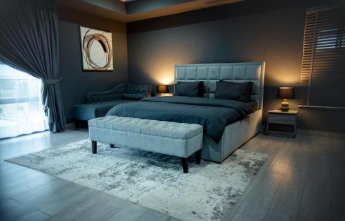 a bedroom with a bed and a chair and a couch at Self made Estates in Accra