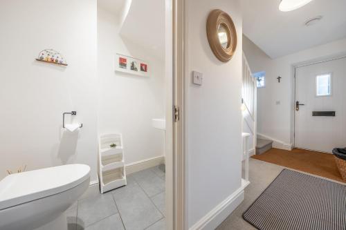 une salle de bain blanche avec toilettes et douche dans l'établissement Victory Cottage, à Little Walsingham