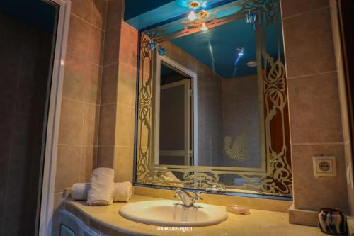 a bathroom with a sink and a mirror at Appartement vue piscine à marina in Agadir