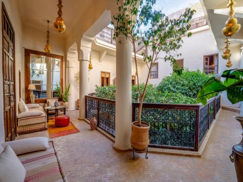 ein Wohnzimmer mit einer Veranda mit einer Pflanze in der Unterkunft Riad Maialou & SPA in Marrakesch