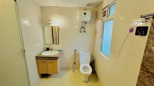 ein kleines Bad mit WC und Waschbecken in der Unterkunft Khushi Home Inn in Noida
