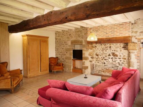 Contigny的住宿－Sous le même ciel，客厅设有红色沙发和砖墙