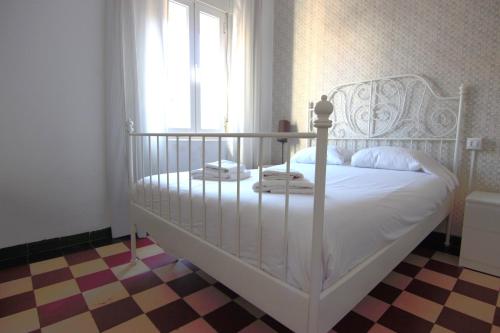 uma cama branca num quarto com uma janela em RentalSevilla cerca del Salvador em Sevilha