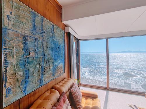Timber's Ocean House في سيمونز تاون: غرفة معيشة مع أريكة ولوحة كبيرة على الحائط