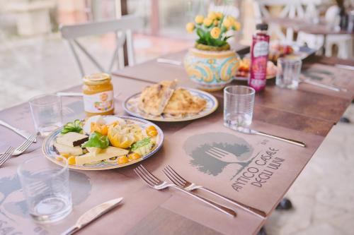 a wooden table with two plates of food on it at B&B Casale degli Ulivi in Avola