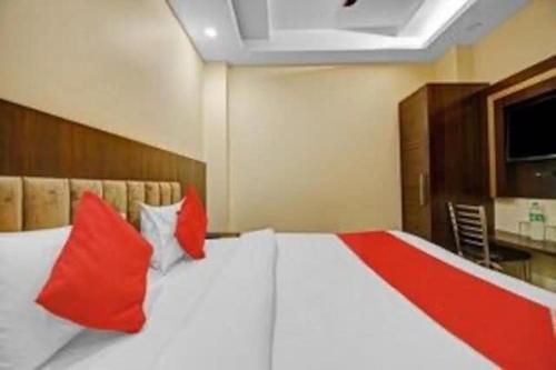 1 dormitorio con 1 cama grande con almohadas rojas en Hotel Silver Street, en Nueva Delhi