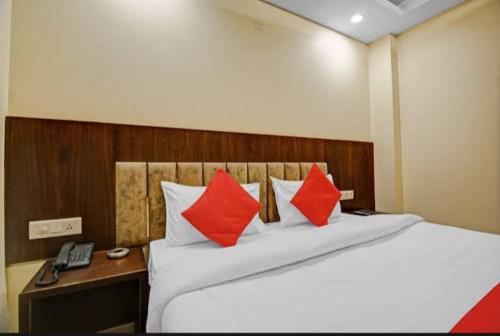1 dormitorio con 1 cama con almohadas rojas y teléfono en Hotel Silver Street, en Nueva Delhi