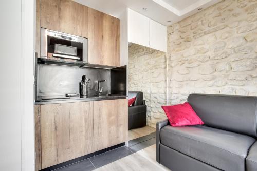 - un salon avec un canapé et un four micro-ondes dans l'établissement Volontaire, à Paris