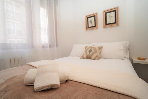 1 dormitorio con 1 cama blanca y 2 almohadas en Centro ciudad, en Lugo