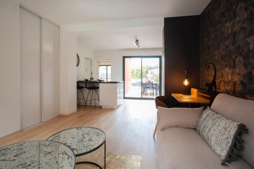 un salon avec un canapé et une table dans l'établissement Appartement Les Jardins de Jules Verne - Côté Jardin, à Amiens