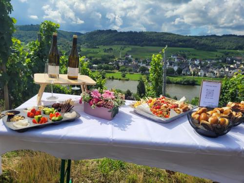 a table with a bunch of food and bottles of wine at Gästehaus Kiebel in Lösnich