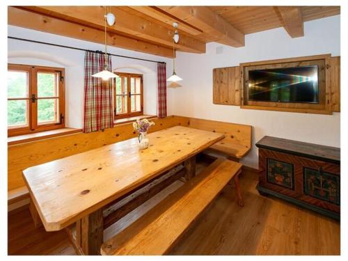 uma sala de jantar com uma mesa de madeira num quarto em Infanglalm "Traunsee" em Neukirchen