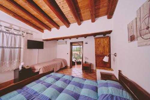 a bedroom with two beds and a television in a room at B&B Casale degli Ulivi in Avola