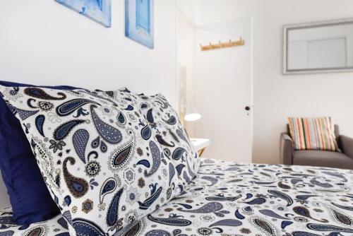 - un lit avec une couverture bleue et blanche et un oreiller dans l'établissement Grand 2 pièces entre vieux Bordeaux et quais !, à Bordeaux