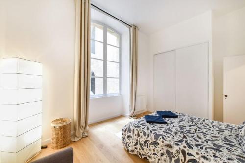 une chambre avec un lit et une grande fenêtre dans l'établissement Grand 2 pièces entre vieux Bordeaux et quais !, à Bordeaux