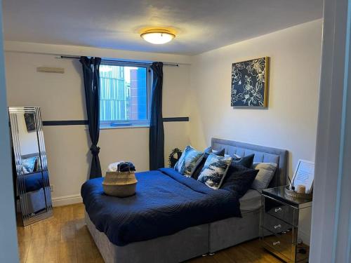 a bedroom with a blue bed and a window at Cosy 1 bed flat, Bham City + Free Parking, Sleeps2 in Birmingham