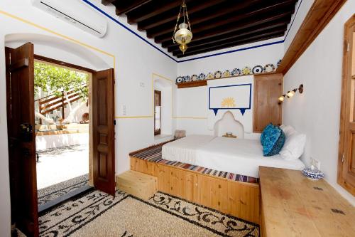 a bedroom with a bed and an open door at Villa Annoula - Traditional Lindian House in Lindos