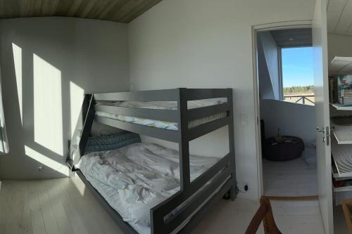a room with a bunk bed in a room with a window at Luxurious design villa near beach - sleeps 8+ in Klintehamn