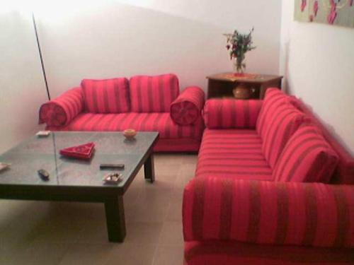 a living room with two red couches and a coffee table at My Second Home in Tunis