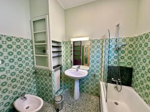 La salle de bains est pourvue de 2 lavabos, d'une douche et d'une baignoire. dans l'établissement APPARTEMENT MAISON, CENTRE VILLE, PROCHE PLAGE TOUT COMMERCE, à Menton