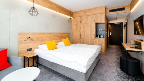 ein Schlafzimmer mit einem Bett, einem Schreibtisch und einem Sofa in der Unterkunft Czarna Perła - Czarna Góra Resort by Sun & Snow z nielimitowanym basenem in Heudorf
