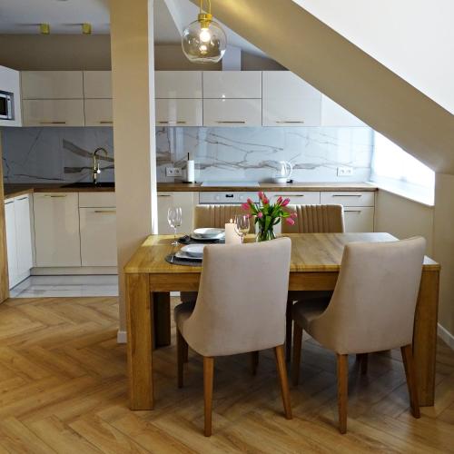 a kitchen and dining room with a wooden table and chairs at Apartamenty u Roxi in Jelenia Góra