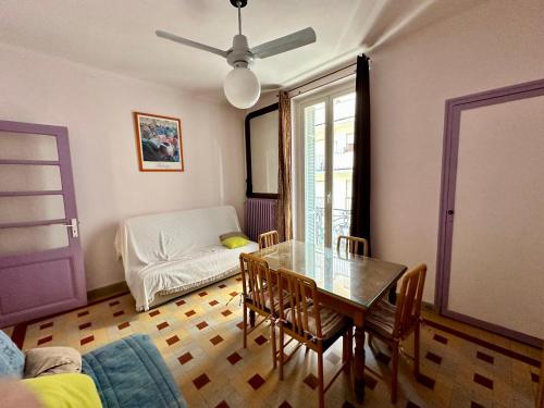 a dining room with a table and chairs and a couch at APPARTEMENT MAISON, CENTRE VILLE, PROCHE PLAGE TOUT COMMERCE in Menton