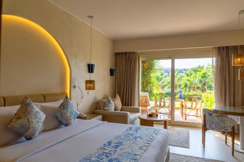 a hotel room with a bed and a balcony at Fort Arabesque Resort, Spa & Villas in Hurghada