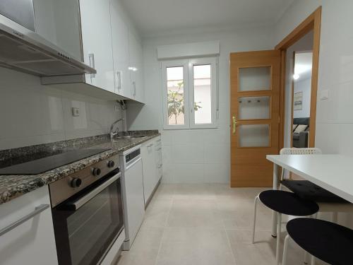 uma cozinha com um lavatório e um fogão forno superior em Apartamento La Planchada em El Astillero