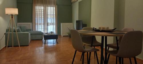 un soggiorno con tavolo, sedie e divano di Modern Home a Salonicco
