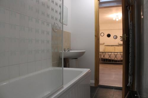 ein Badezimmer mit einer Badewanne und einem Waschbecken in der Unterkunft Impeccable Spacious 6-Bed House in Romford in Romford