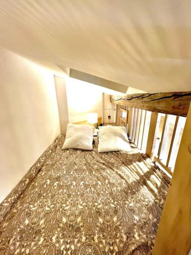 - un grand lit avec deux oreillers dans une chambre dans l'établissement T1 Bis au coeur du centre historique, à Bordeaux