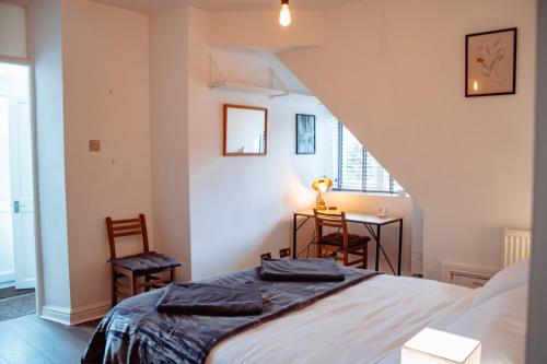 Schlafzimmer mit einem Bett, einem Tisch und Stühlen in der Unterkunft Spacious Flat with Free Parking in Harrogate