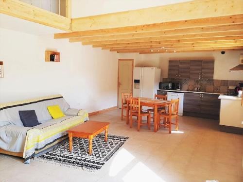 un salon avec un canapé et une table et une cuisine dans l'établissement Sous le Grand Chêne, gîte à la ferme, Finistère, à Pouldergat