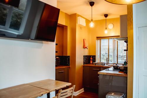 哈羅蓋特的住宿－Spacious Flat with Free Parking，厨房配有木桌和水槽。