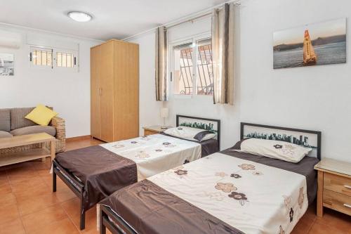 a bedroom with two beds and a couch at Villa Dos Perlas in Alicante